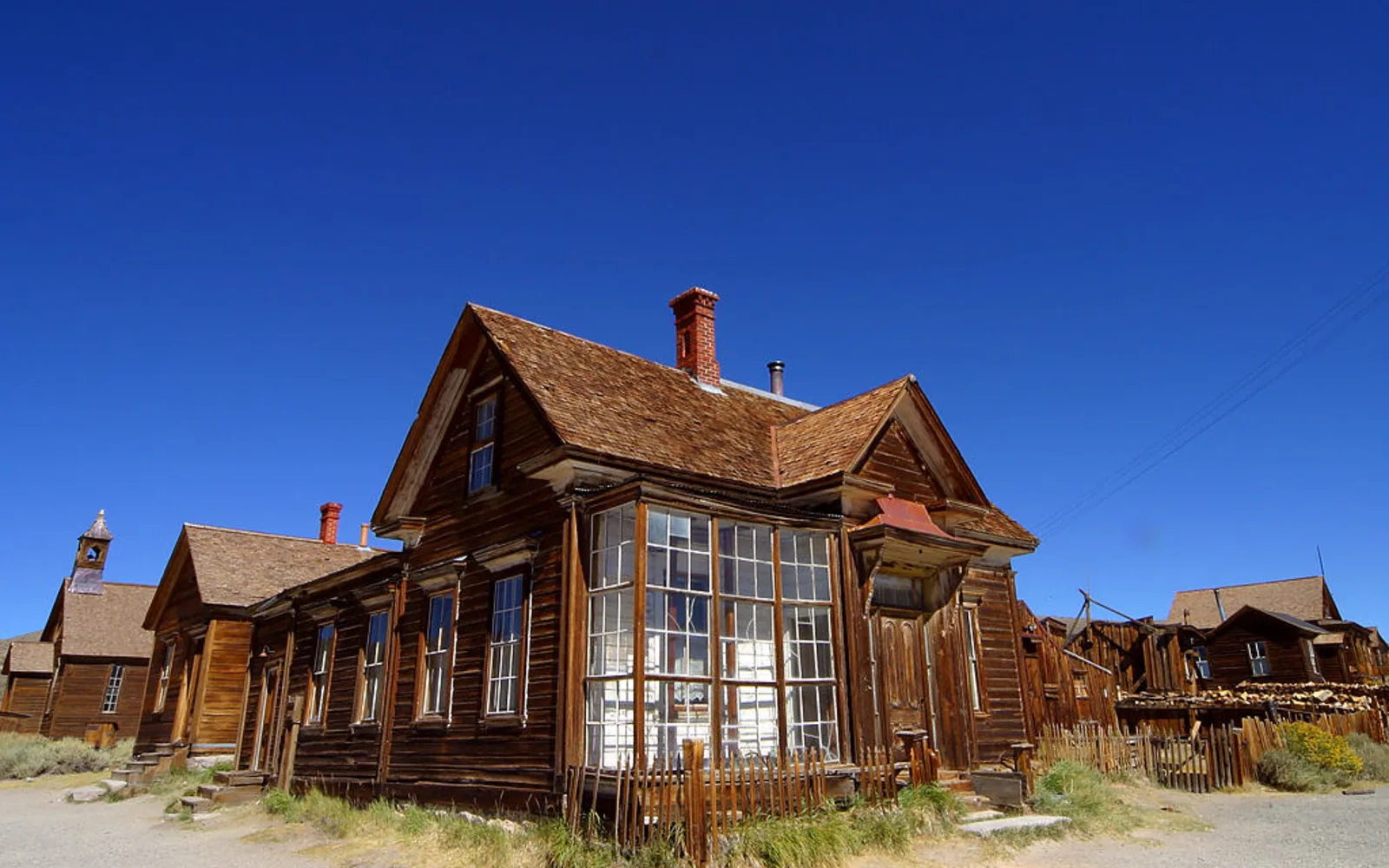 A wooden building in Bodie, a historic California ghost town, with bare landscape in the background